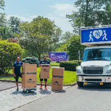 Movers delivering boxes to a happy client's home