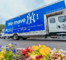 Roadway Moving truck driving through a neighborhood with flowers